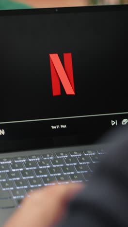 vertical video bucharest, romania - july 30th 2024 - young ceo using netflix to relax in office