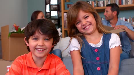 hermanos sonrientes desempaquetando cajas