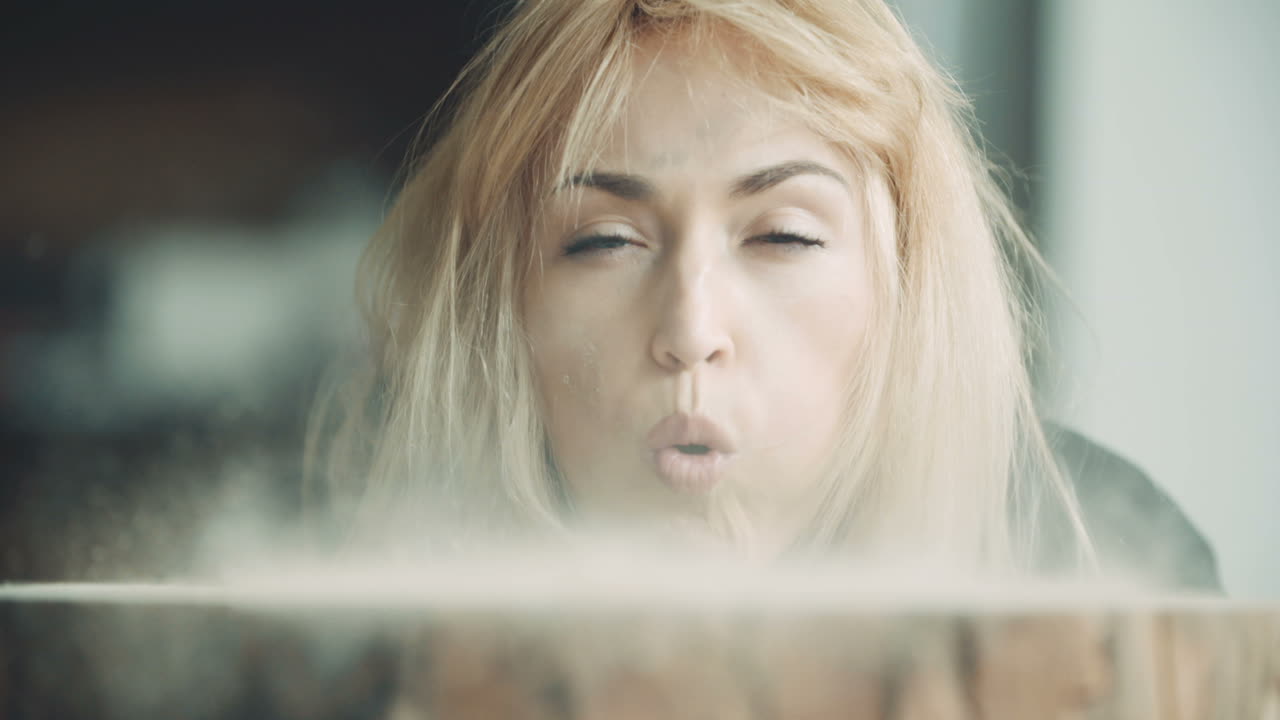 나무 그루터기에 톱밥을 불고 있는 여성 목수