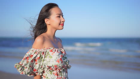 여름 드레스를 입고 모래사장에 서 있는 젊은 아시아 여성의 머리카락, 슬로우 모션