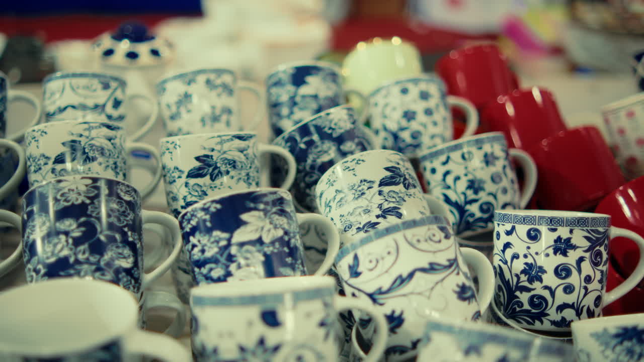 A vibrant display of handcrafted ceramic mugs with intricate blue and white patterns, capturing the essence of local commerce and artisanal craftsmanship
