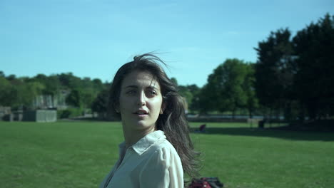 rotating camera around a gorgeous italian fashion model posing in her outfit in a park in london at golden hour