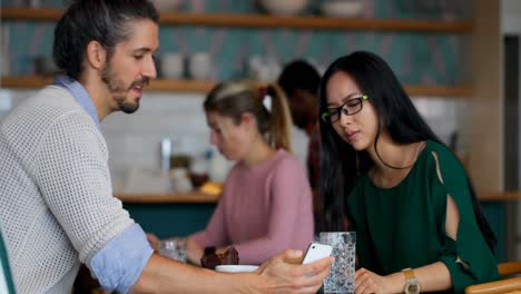 Business-colleagues-discussing-over-mobile-phone-in-office-4k