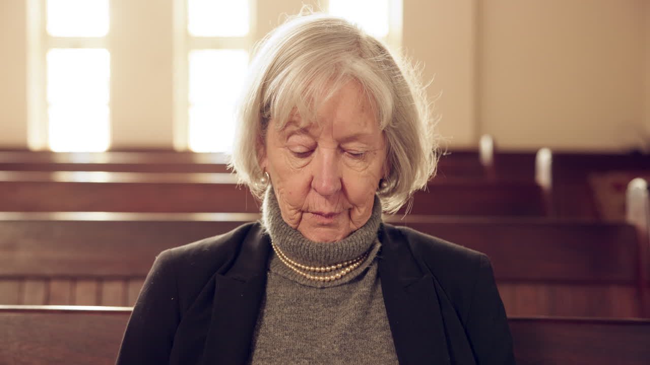 Funerale, chiesa e donna anziana triste su una panchina