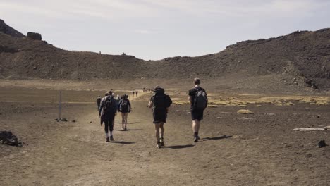 group of hikers on the pathways towards tongariro alpine crossing in new zealand