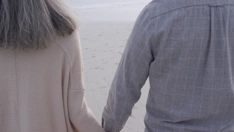 pareja madura disfrutando del tiempo afuera junto al mar