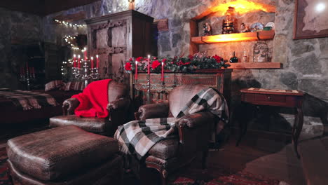 cozy living room with christmas decorations. christmas decorated room with many lights, candles and red light. room with armchairs and carpet