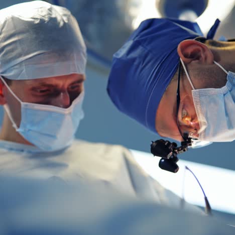 specialists providing operation with modern technology equipment in hospital. back view of doctors looking on monitor during operation. surgery in hospital