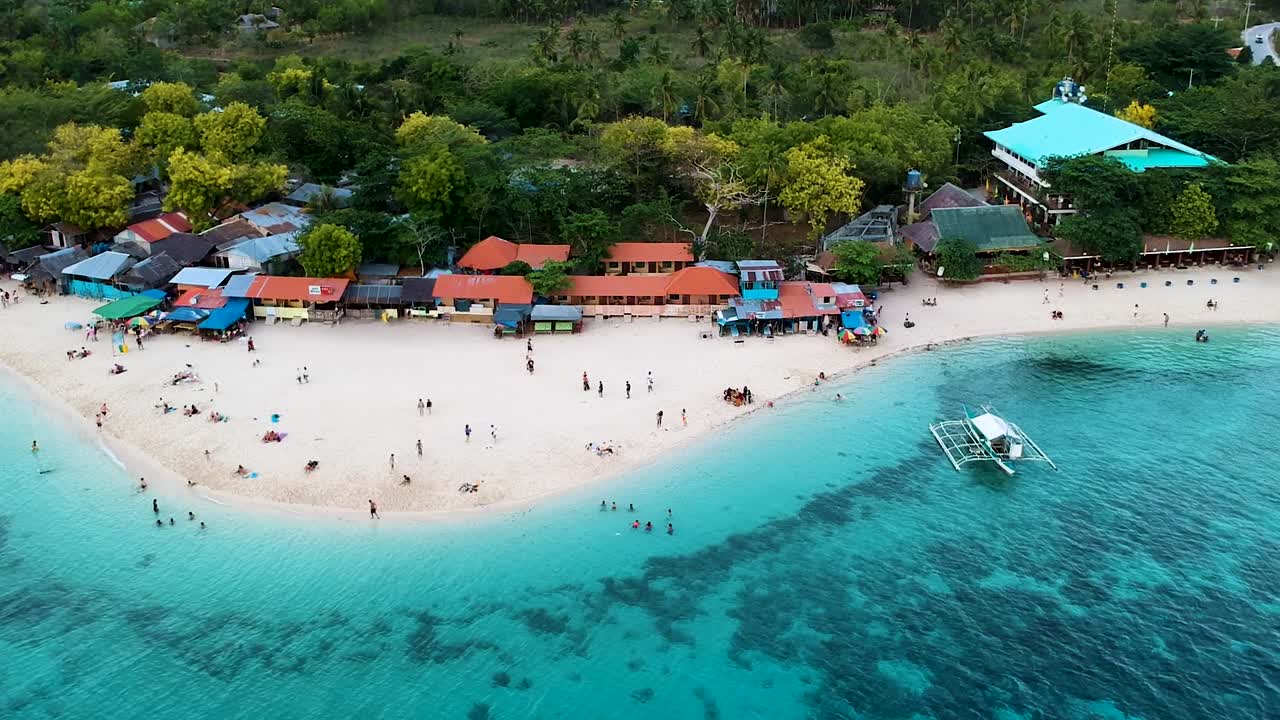 Panoramica aerea lungo una spiaggia affollata di sabbia bianca