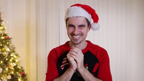 crazy man wearing santa hat and jumper rubbing hands with insane grinning and laughing facial expression