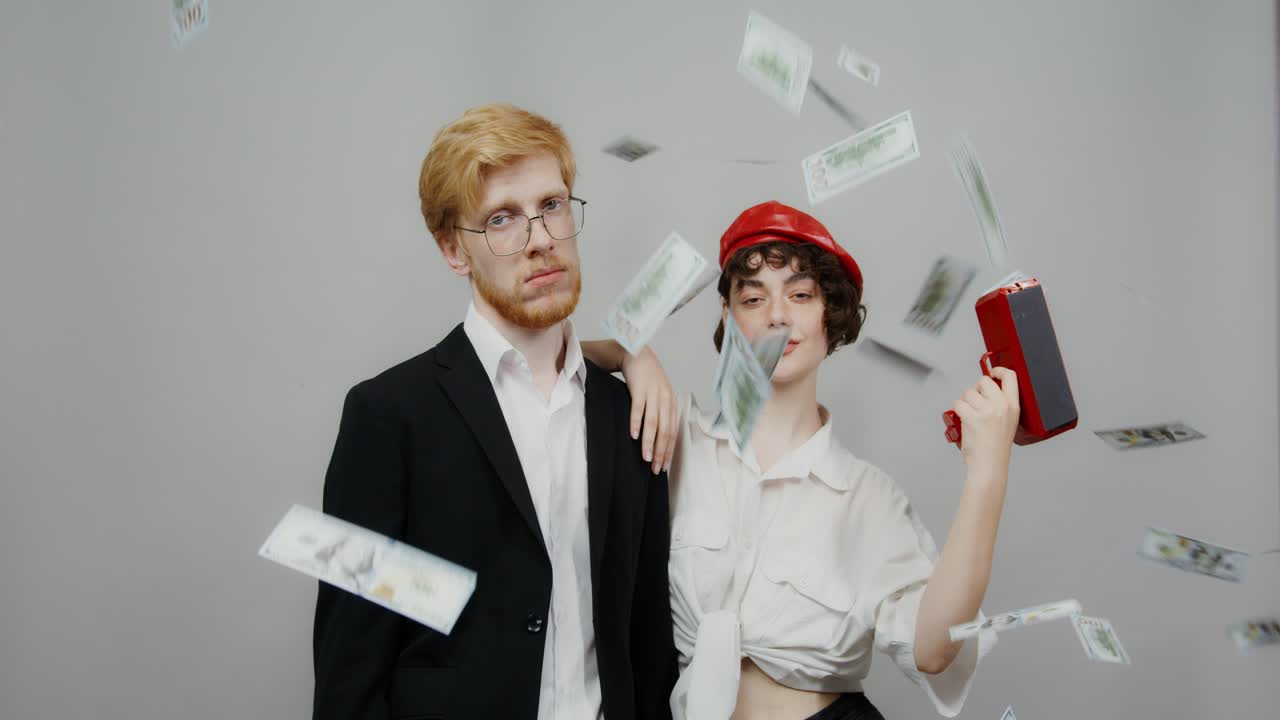 пара позирует с падающими деньгами