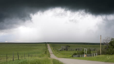 country road and rolling hills as dark textured clouds move over head