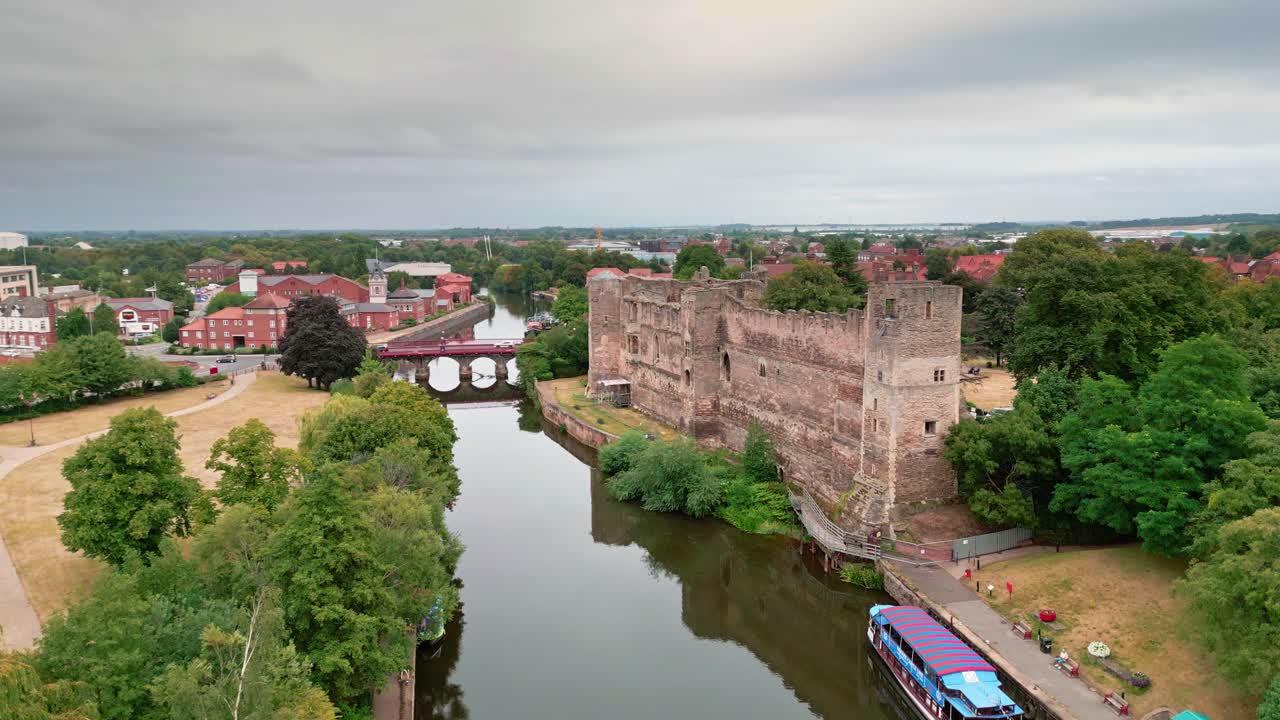 una grúa disparada en un dron que se eleva sobre el río trent mirando el castillo de newark