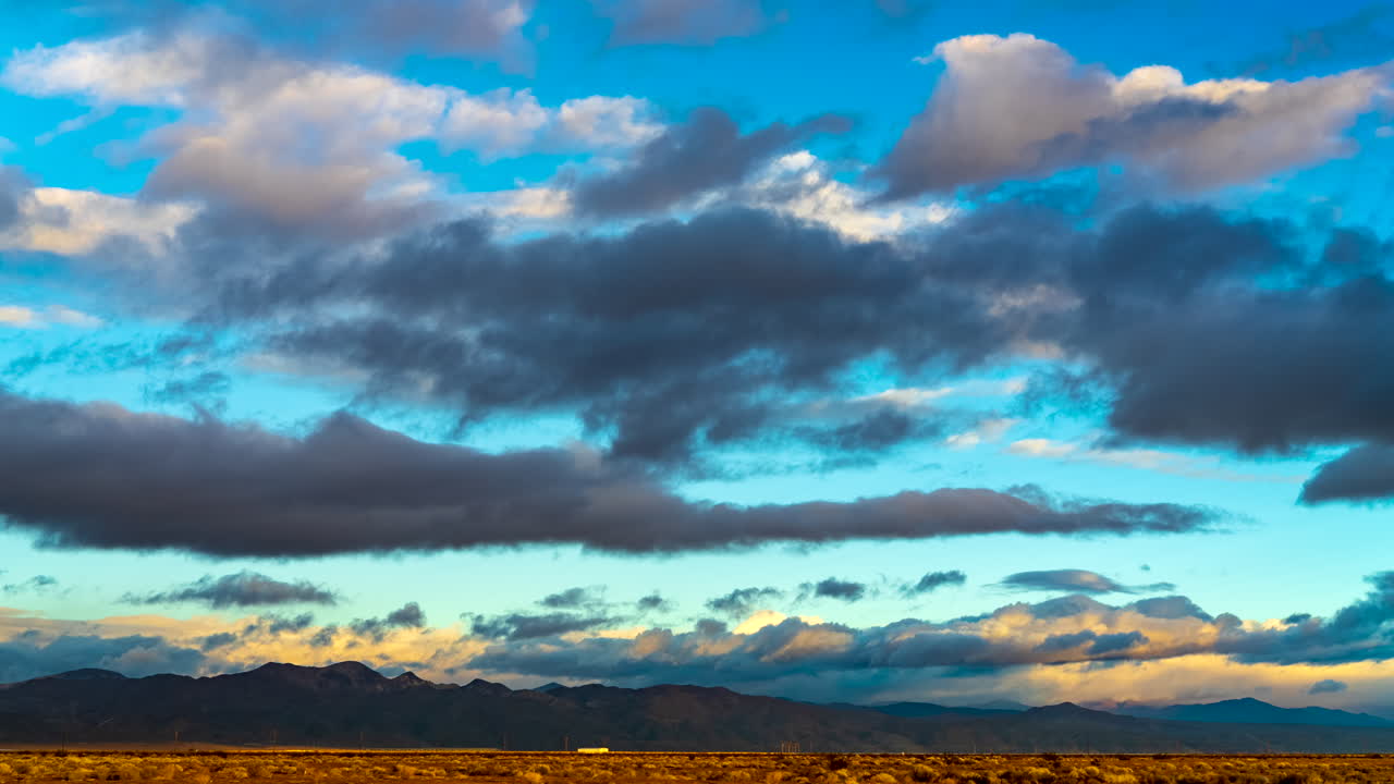 paisaje nublado colorido sobre el paisaje del desierto de mojave y montañas escarpadas al atardecer - lapso de tiempo de gran angular
