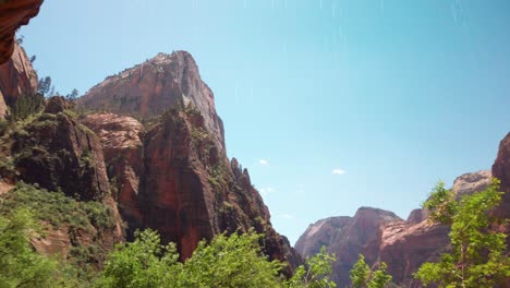 panning shot across zion canyon rock peaks with weeping rock weeping in the foreground