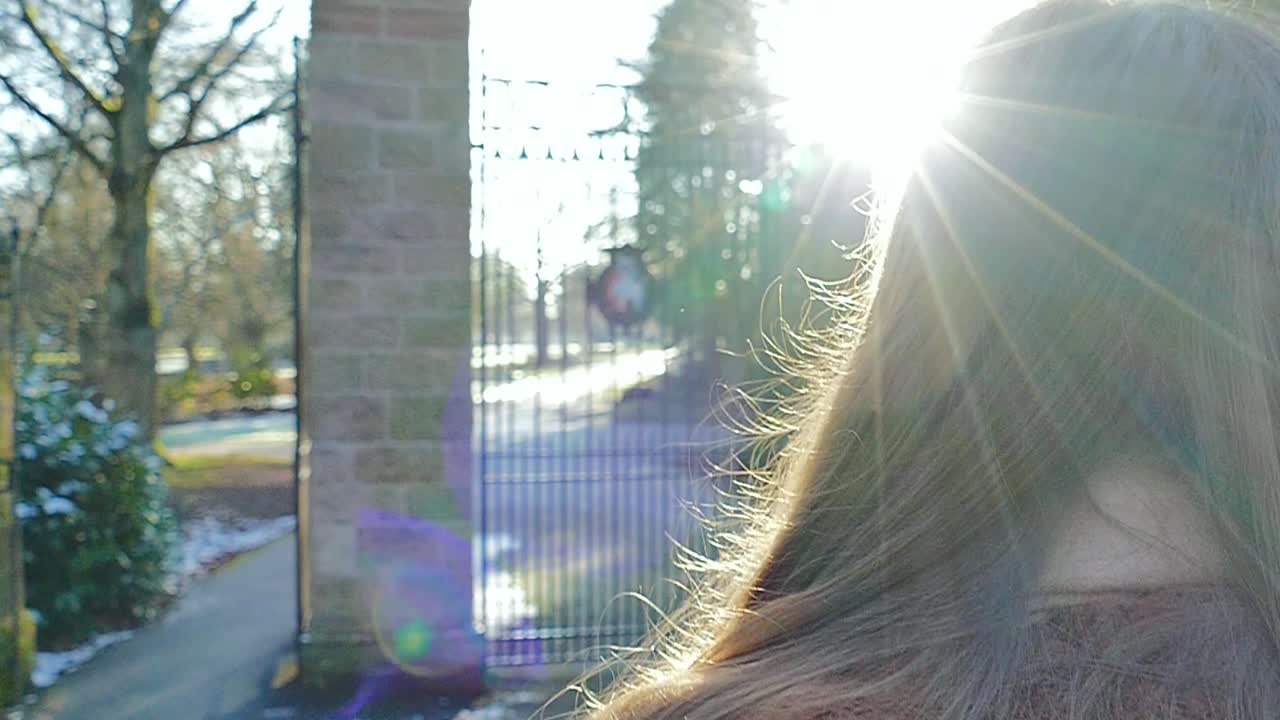 Slow motion (120fps): young lady walks into the park (War memorial park) in Coventry, United Kingdom