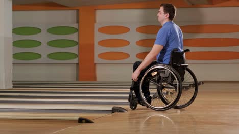 two young disabled men in wheelchairs playing bowling in the club