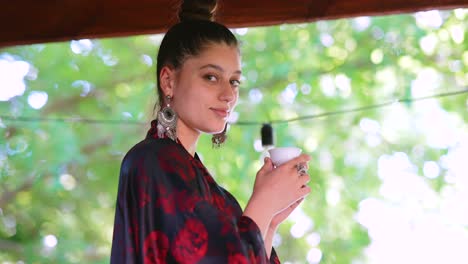 una mujer joven disfrutando de una bebida en un jardín