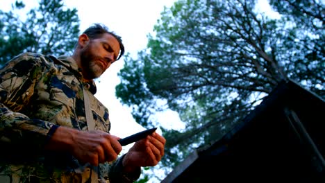 man holding hunter knife in the forest 4k