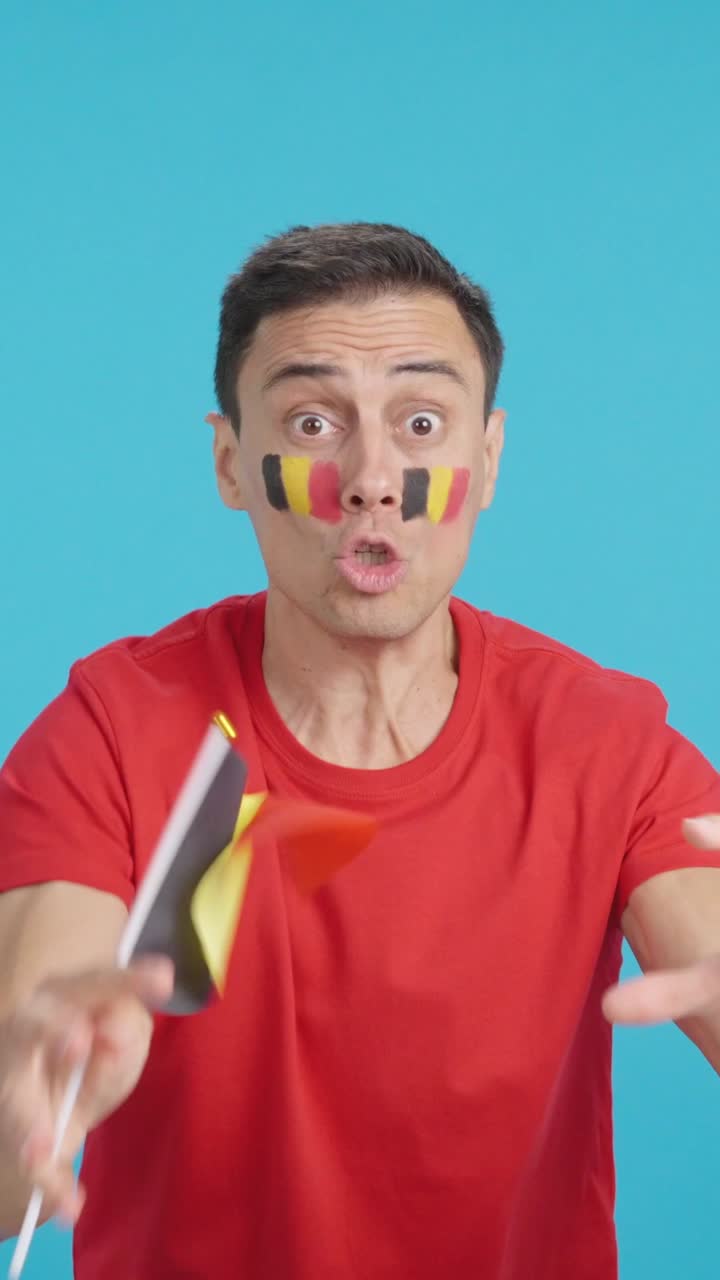 Man cheering for Belgium screaming and waving a national flag