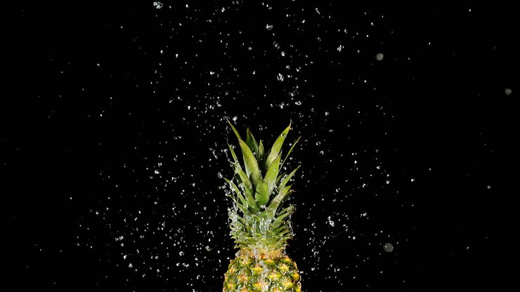 piña levantada por una corriente de agua - una dulce fruta tropical lista para comer, macro y cámara lenta