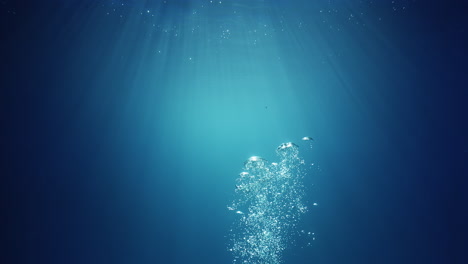 Underwater-sunlight-beams-shining-from-above-coming-through-the-deep-crystal-clear-blue-water-causing-a-beautiful-water-lighting-reflections-curtain-with-air-bubbles-rising-up-to-the-surface