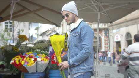 handsome young man buying flowers on the street