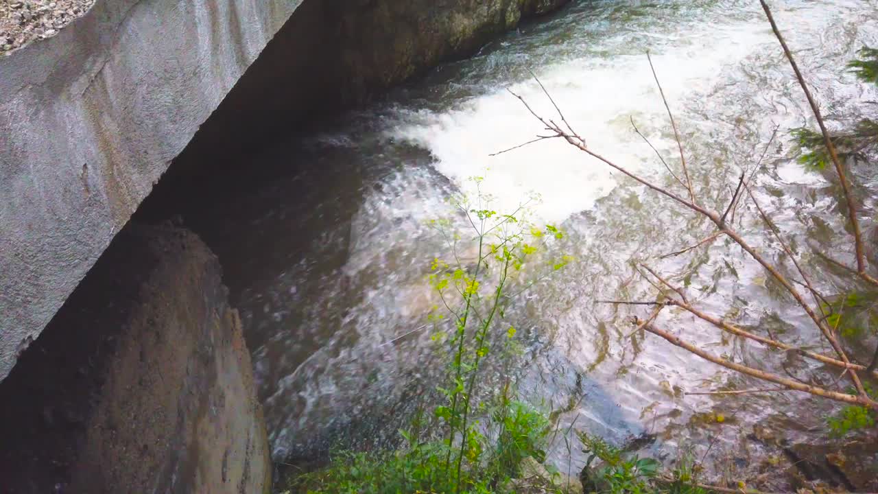 A simple, fast-flowing stream under a bridge