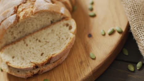 video of bread on chopping wooden board on wooden worktop