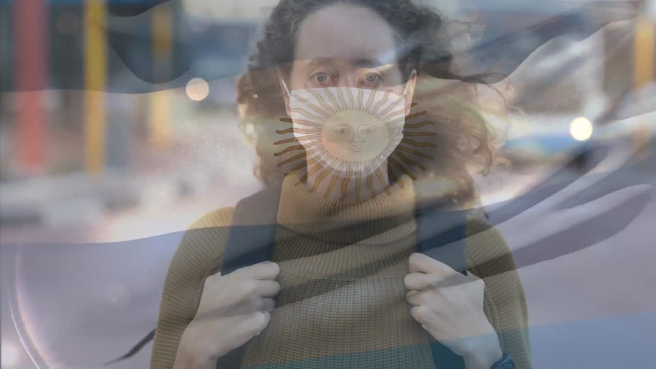 bandera argentina ondeando contra una mujer con máscara facial