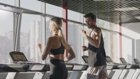 running couple training cardio exercise on treadmill machine in fitness center