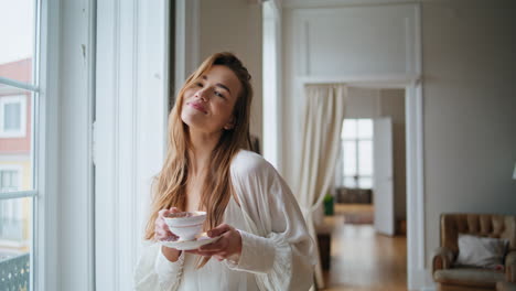 Positives-Mädchen,-Das-Zu-Hause-Tee-Trinkt.-Lächelnde-Frau,-Die-Zu-Hause-Mit-Der-Kamera-Posiert