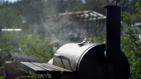 smoke coming out from round metal smokehouse.