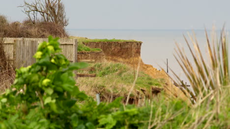 Weite-Aufnahme-Der-Küstenerosion-Der-Klippen,-Die-Ehemalige-Gartenzäune-Und-Pflanzen-In-Happisburgh-Im-März-2024-Zeigt