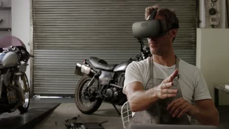 mecánico masculino usando auriculares de realidad virtual en un garaje de reparación de motocicletas 4k