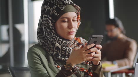 Porträt-Einer-Geschäftsfrau-Im-Hijab-Mit-Smartphone-Im-Büro