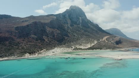 fotografía aérea de la montaña en la costa con nubes alrededor del pico