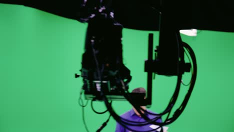 camera crane he follows the television male presenter in the green studio. chroma key. broadcasting industry