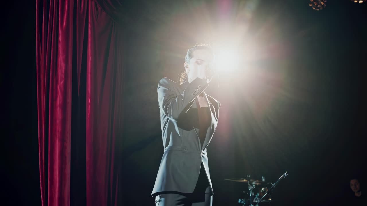 Dynamic video still of a singer on stage, captured from a low angle