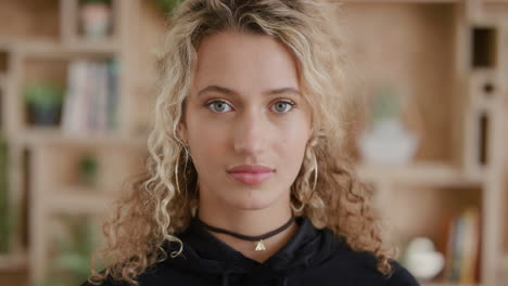 portrait of beautiful young blonde woman looking serious at camera attractive female student