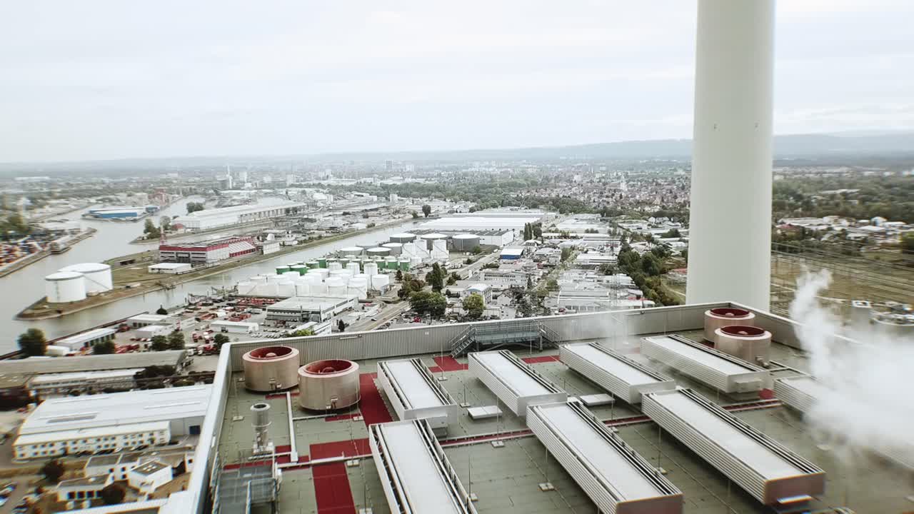 vuelo de drones a gran altura sobre el techo de un edificio gigante de una planta de energía de carbón en europa occidental con humo y cielos nublados