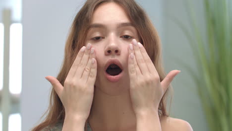 face of young woman doing face massage