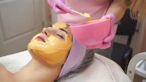 face peeling mask. woman getting facial care by beautician at spa salon. cosmetologist job. close-up