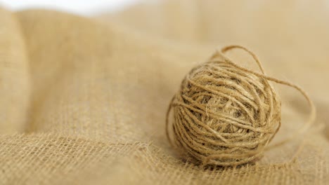 closeup of a hand grabbing a ball of burlap, natural jute hessian fibre textile