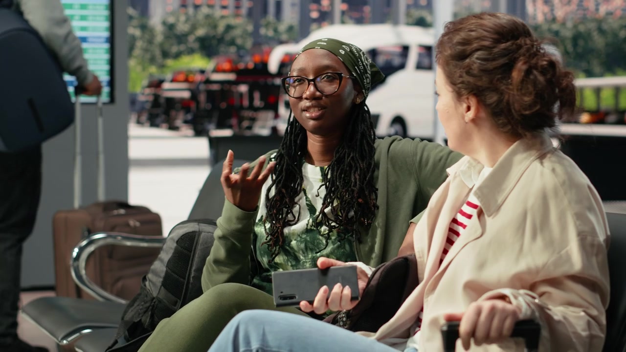 Close up of smiling women discussing route plans in coach station