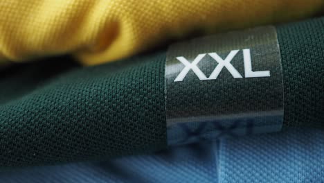 xxl size clothing tag on stacked polo shirts