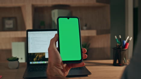 entrepreneur swiping chroma key mobile phone making purchase at home close up.
