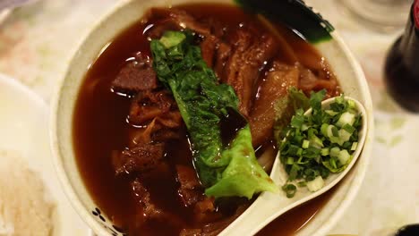 delicious noodle soup with meat and greens