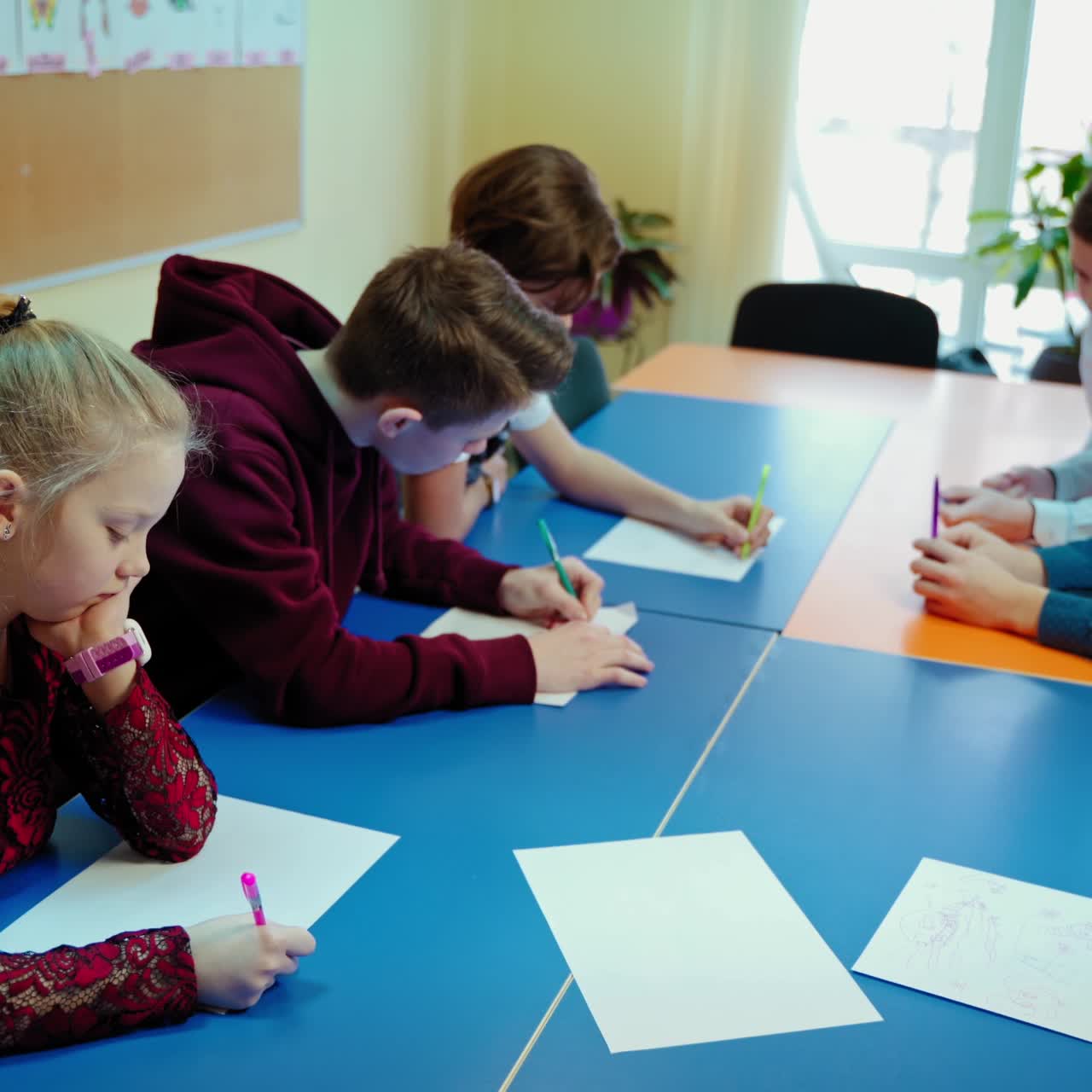 Students in the classroom. Pupils study at one big table together at private school. Education concept.