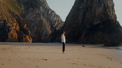una mujer en una playa al atardecer.